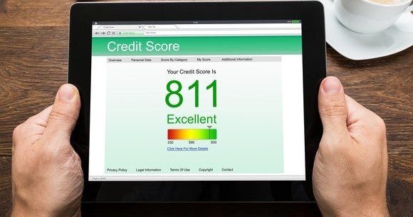 Hands holding tablet show 811 credit score
