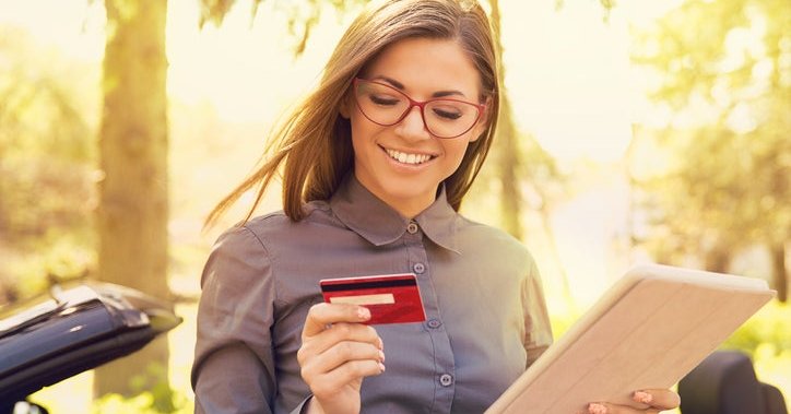 A smiling woman with a credit card.