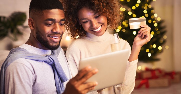 A couple shops online with a credit card during the holiday season