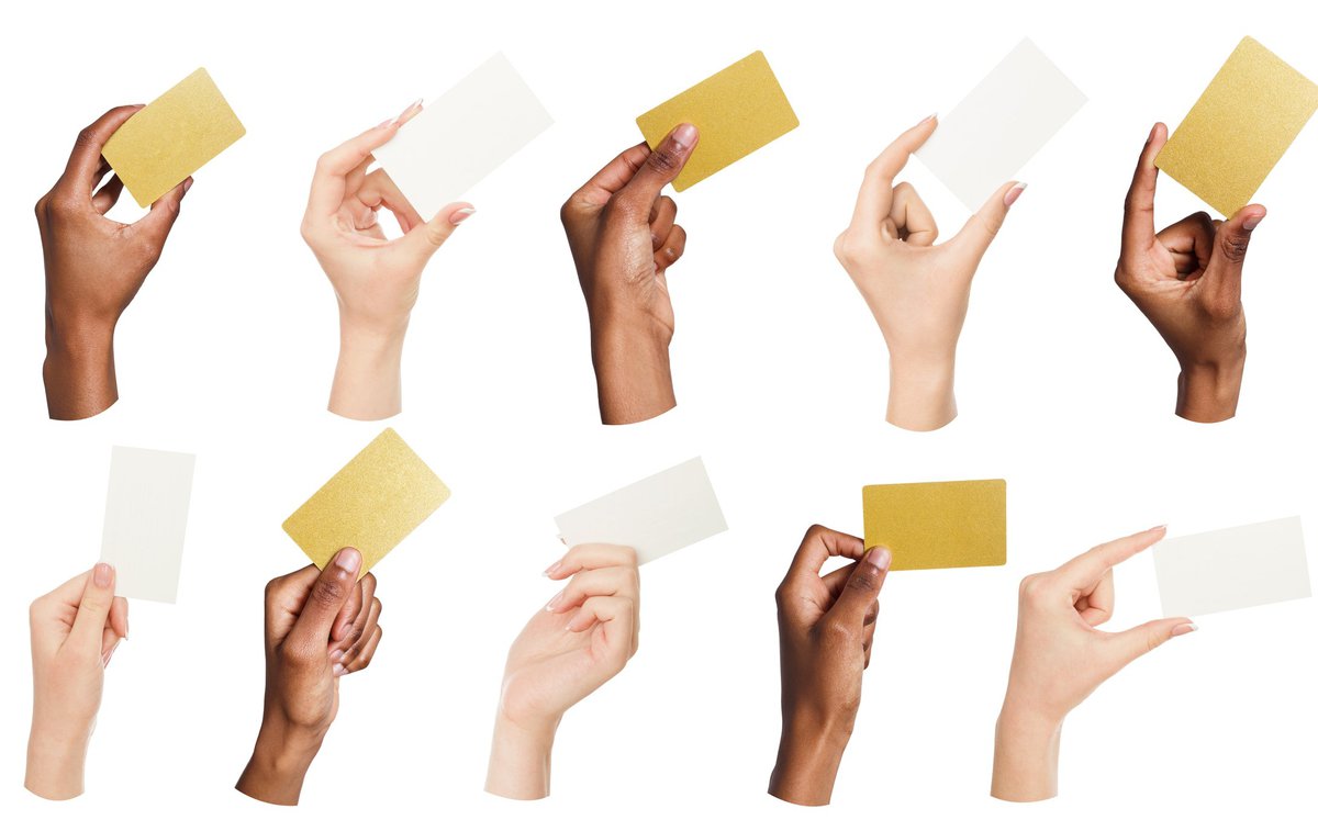 Different hands holding up various credit-card-sized nondescript note cards.