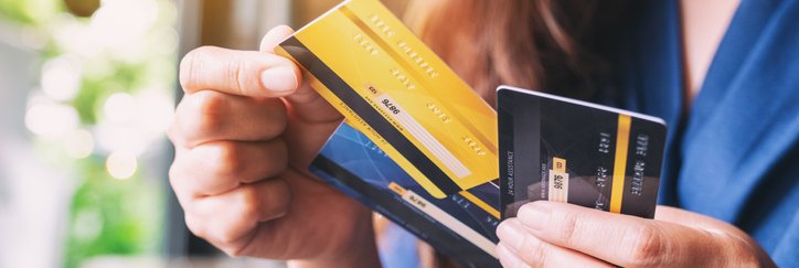 A woman holds three credit cards.