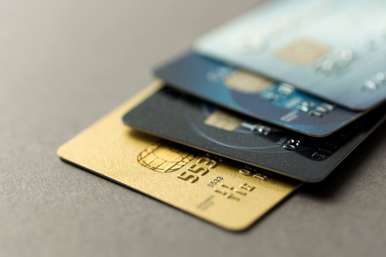 A pile of four different credit cards in various finishes.