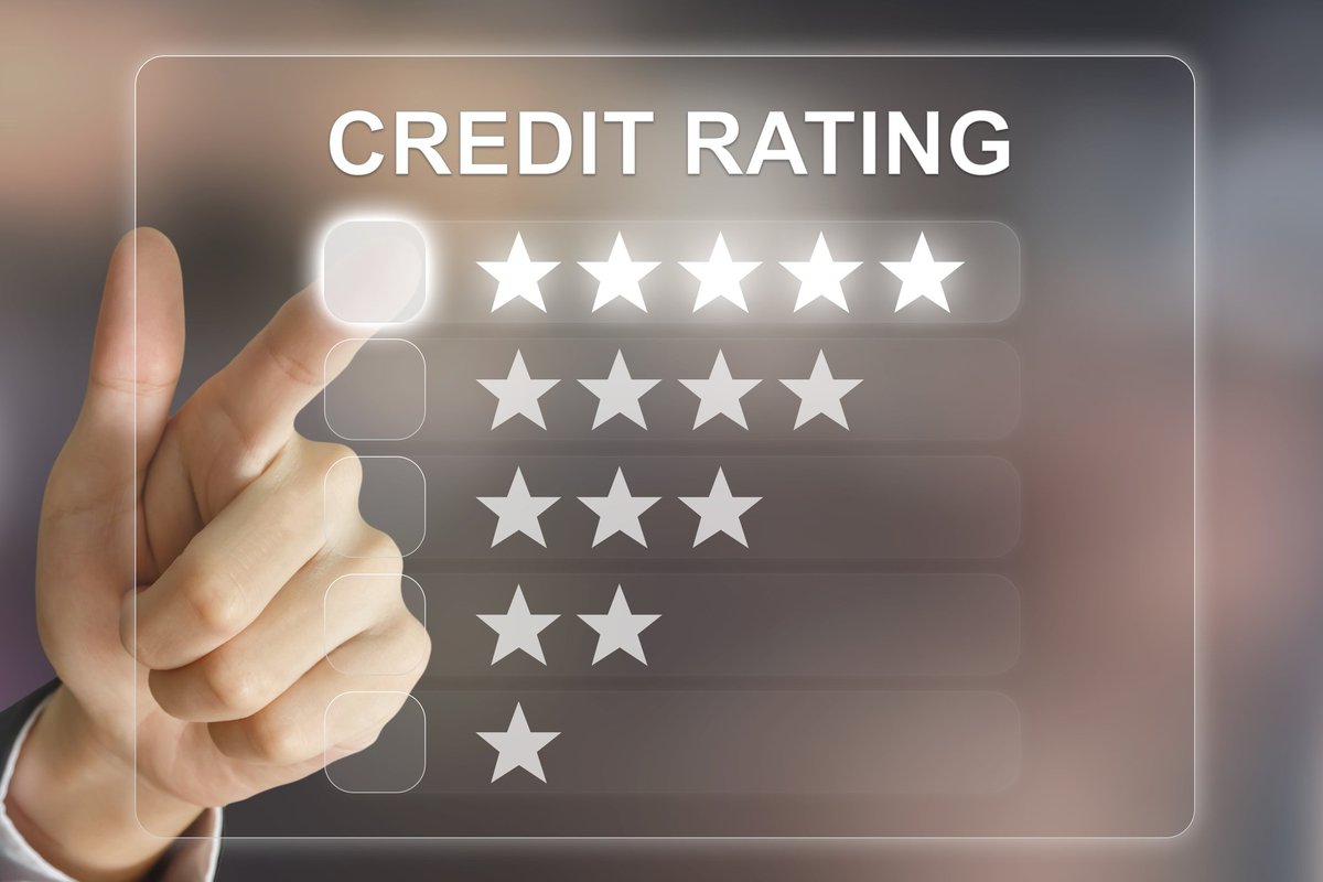A finger pointing to a Credit Rating scoring system on a screen with one through five star options.