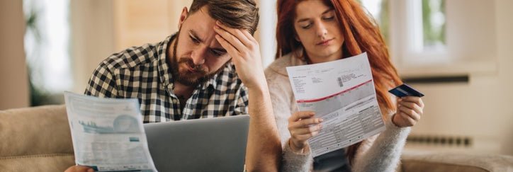 A worried couple looking at bills.