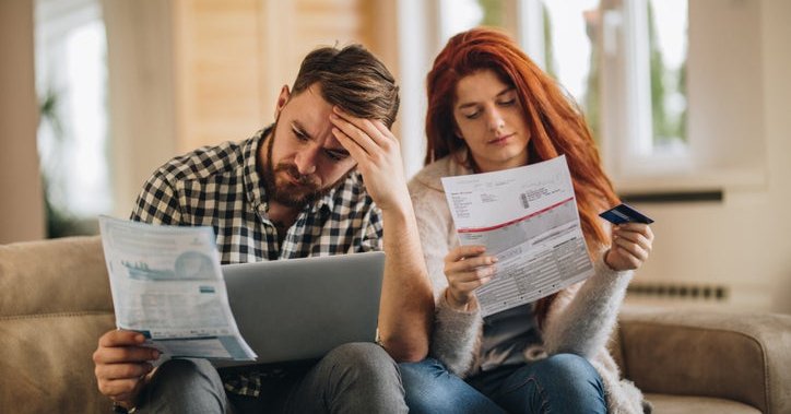 A worried couple looking at bills.
