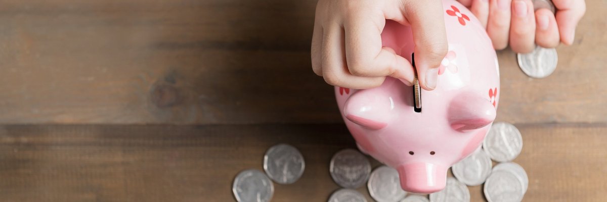 Han dropping coins into a piggy bank.