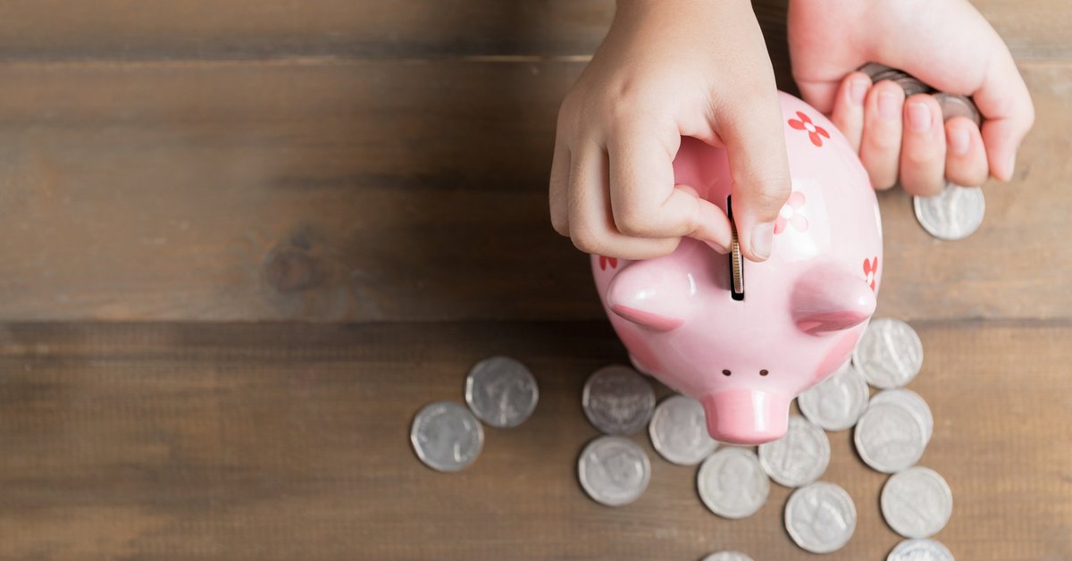 Han dropping coins into a piggy bank.