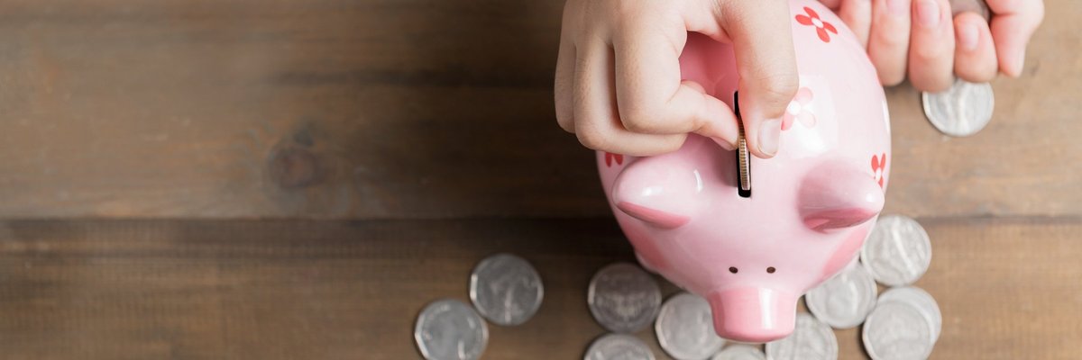 Han dropping coins into a piggy bank.
