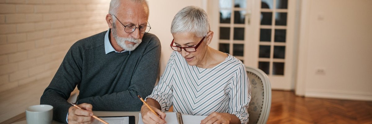 elderly couple with notebook and calculator