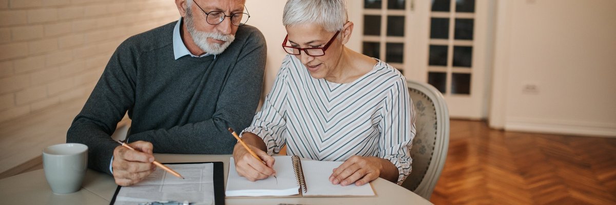 elderly couple with notebook and calculator