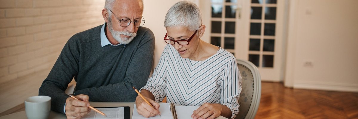 elderly couple with notebook and calculator