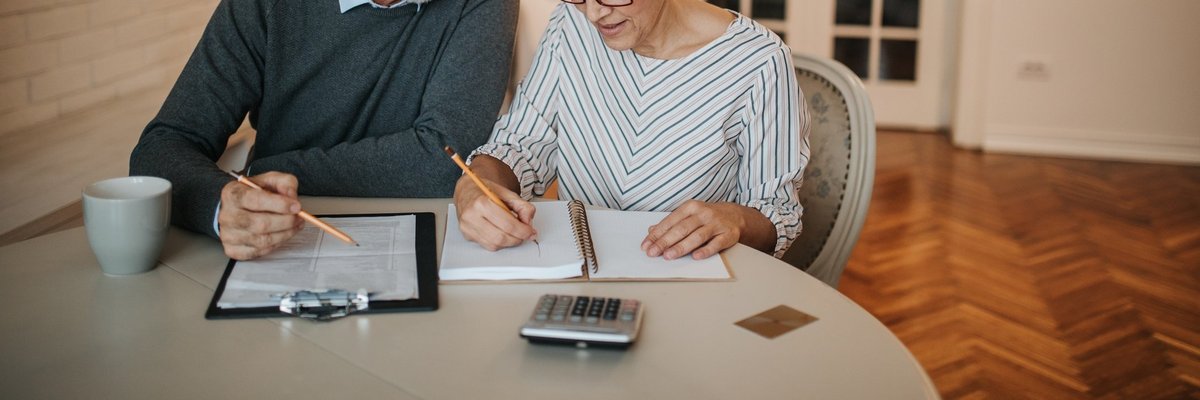 elderly couple with notebook and calculator