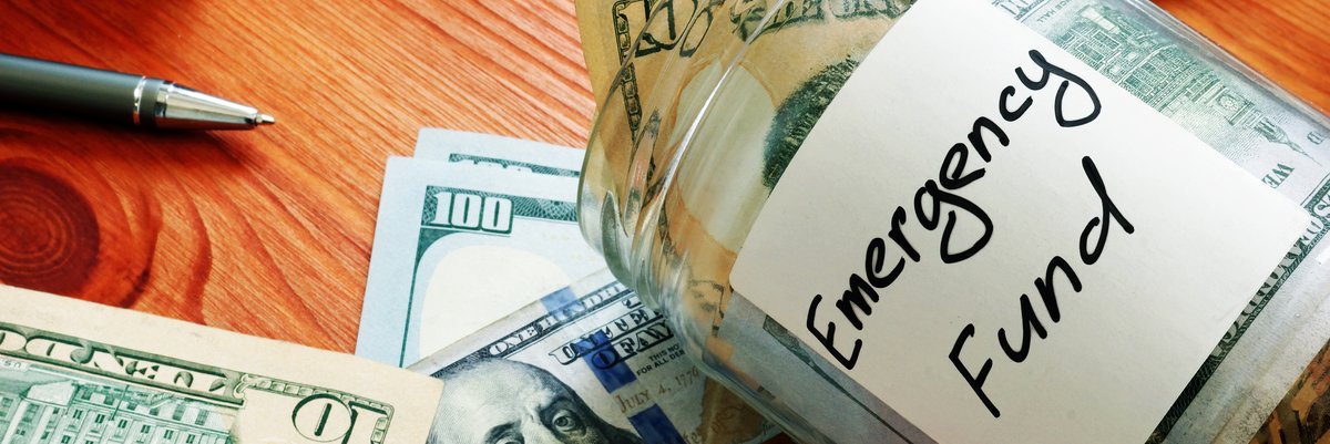A jar labeled emergency fund holding a stash of cash.
