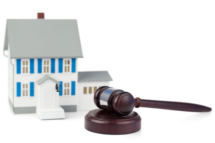 A gavel next to a toy house.