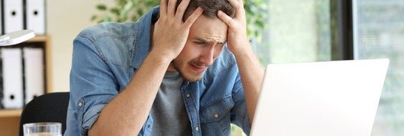 man looking at computer frustrated and confused