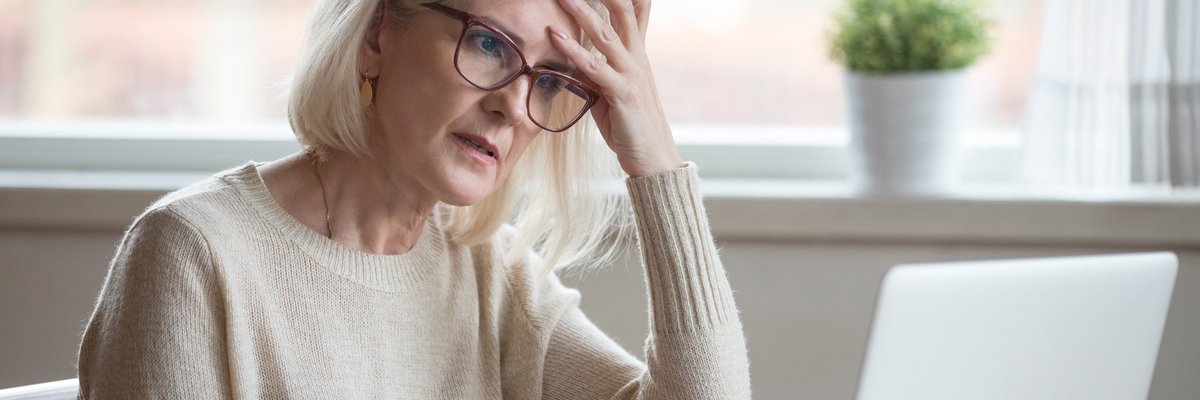 Senior woman looking at laptop with frustrated expression