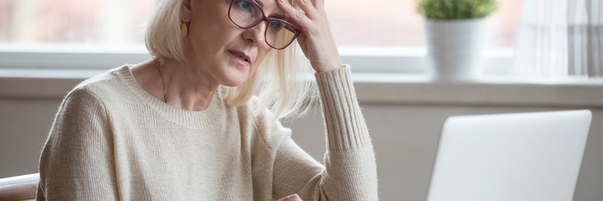 Senior woman looking at laptop with frustrated expression