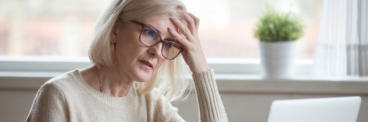 Senior woman looking at laptop with frustrated expression