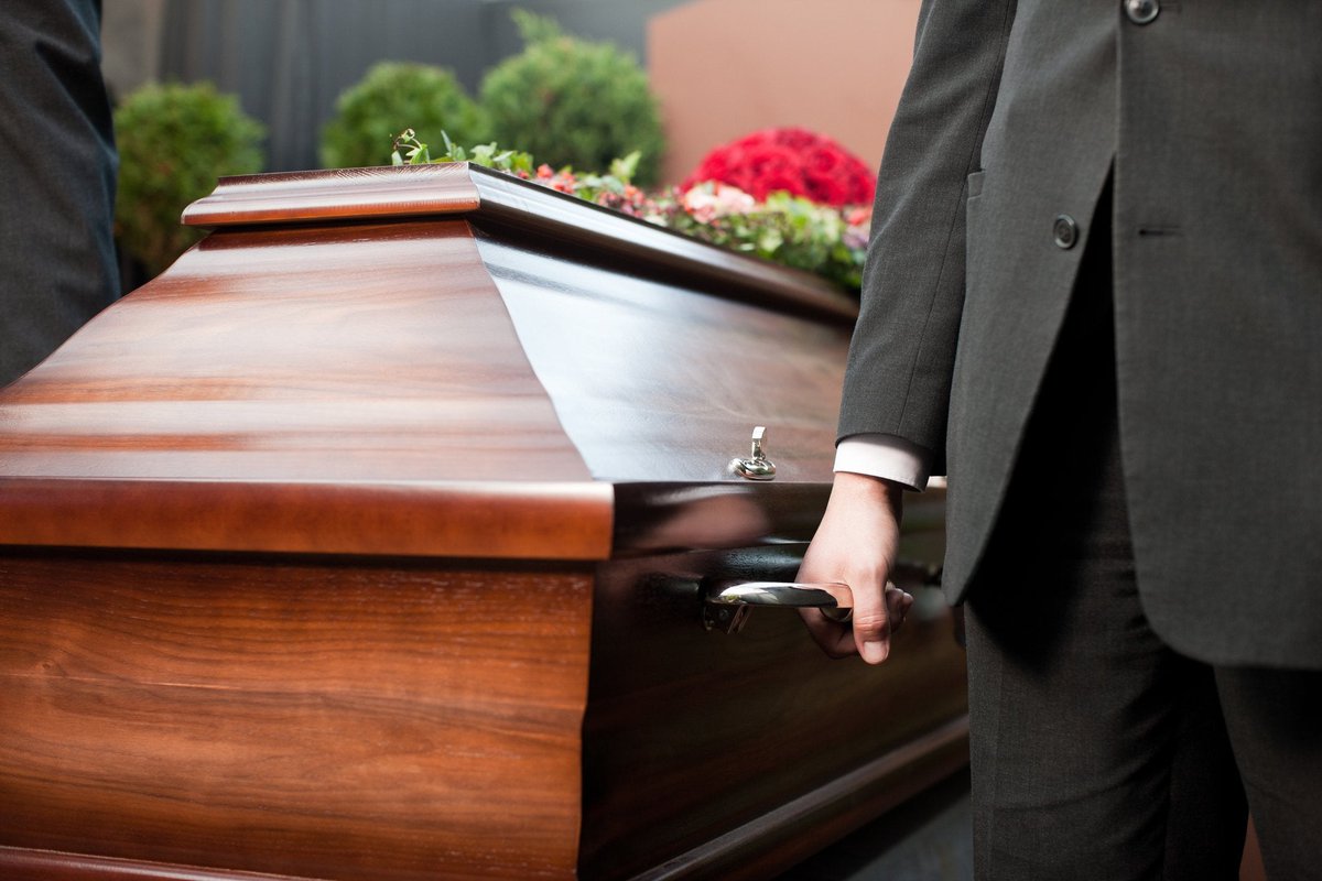 Casket being carried by men in suits.