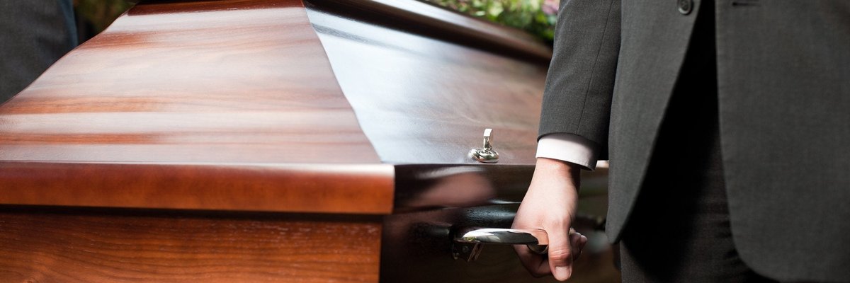 Casket being carried by men in suits.