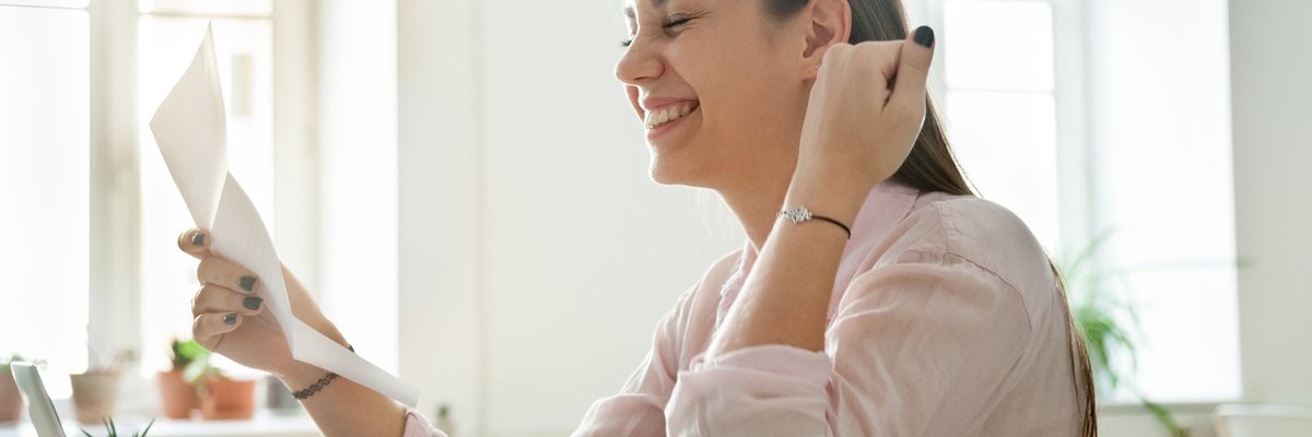 woman smiling and looking at paperwork
