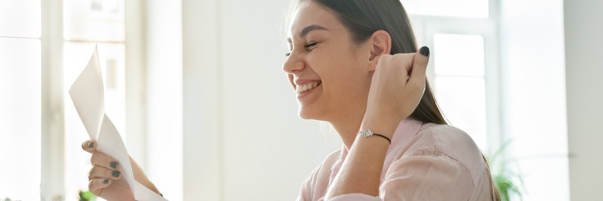 woman smiling and looking at paperwork