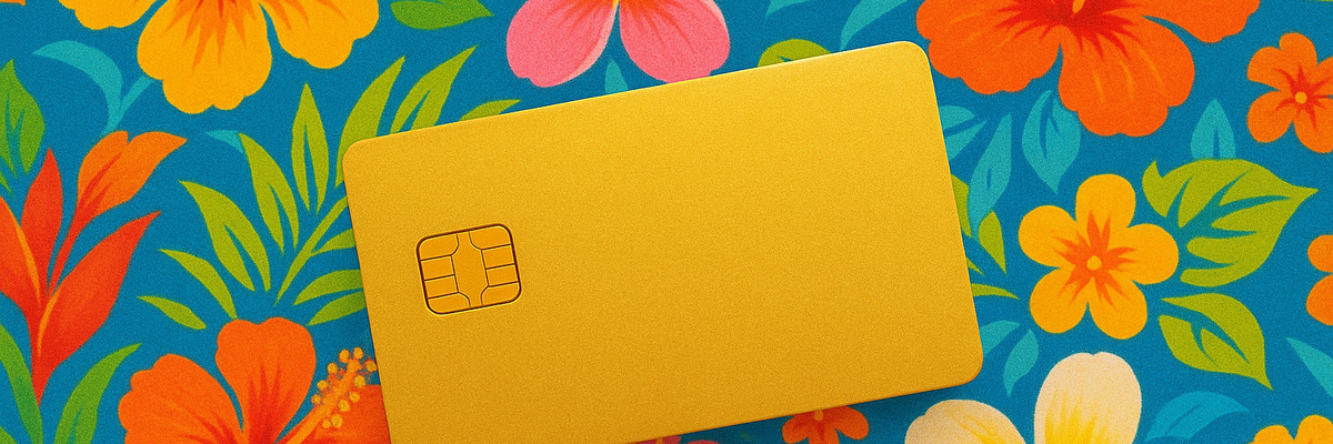 A gold credit card against tropical floral background.