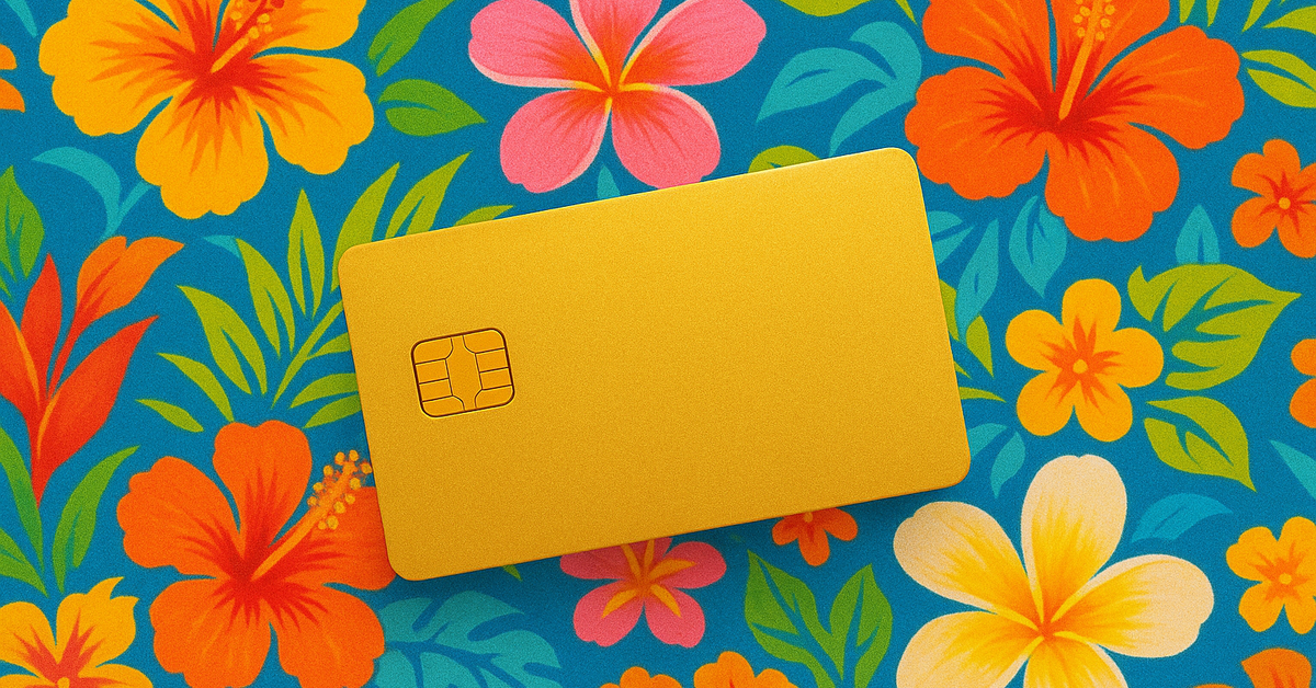 A gold credit card against tropical floral background.
