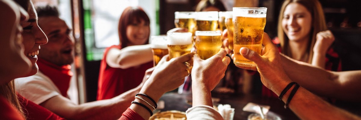 A group of friends cheersing their beers at happy hour.