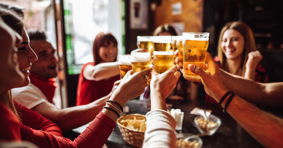 A group of friends cheersing their beers at happy hour.
