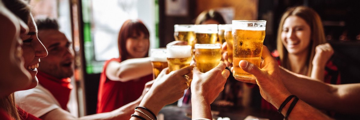 A group of friends cheersing their beers at happy hour.