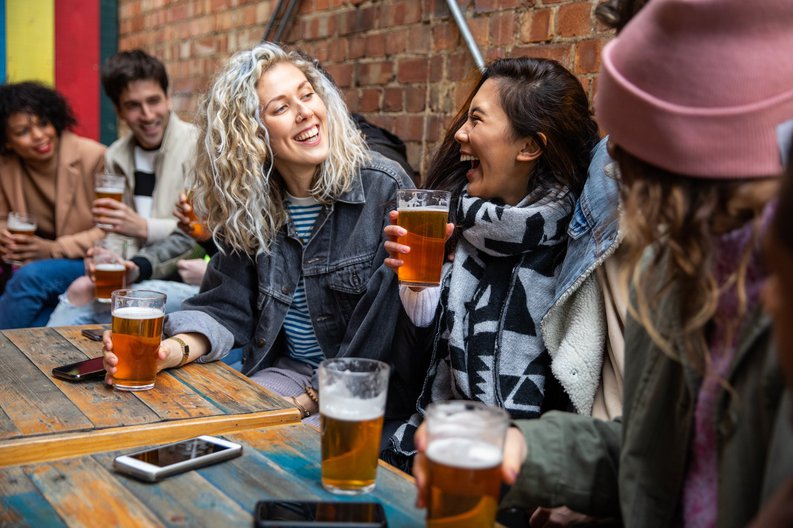 A group of friends drinking beer at a pub.