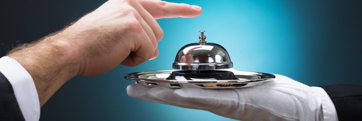 Someone rings a service bell held by a gloved hand