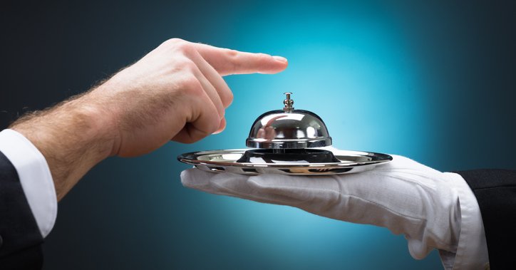 Someone rings a service bell held by a gloved hand