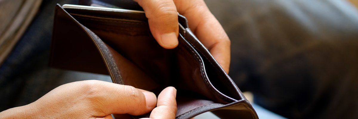 Hands open up a wallet showing that the inside is empty.