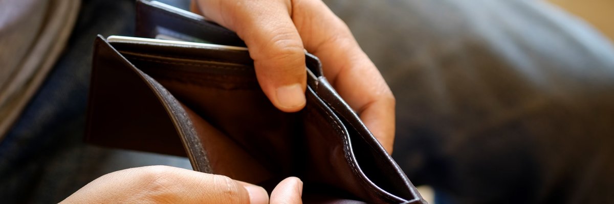 Hands open up a wallet showing that the inside is empty.