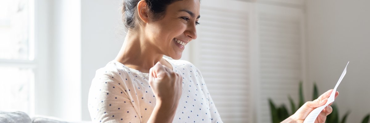 A woman pumps her fist and smiles.