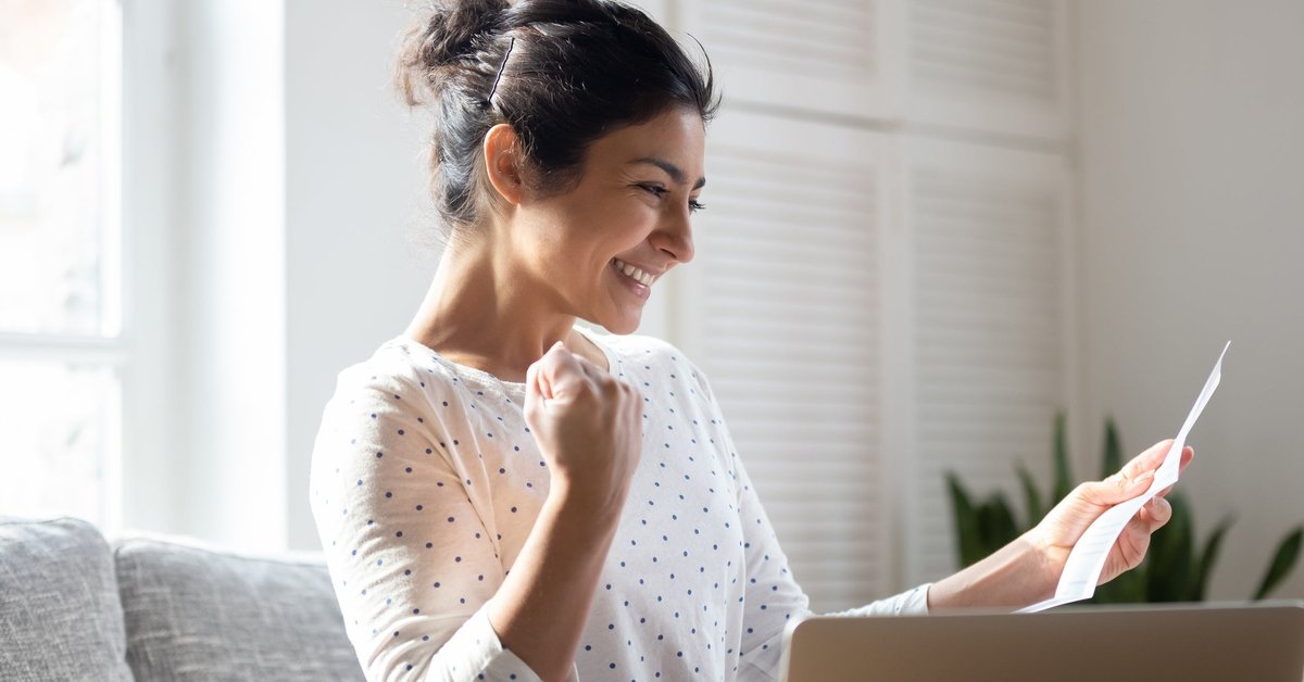A woman pumps her fist and smiles.