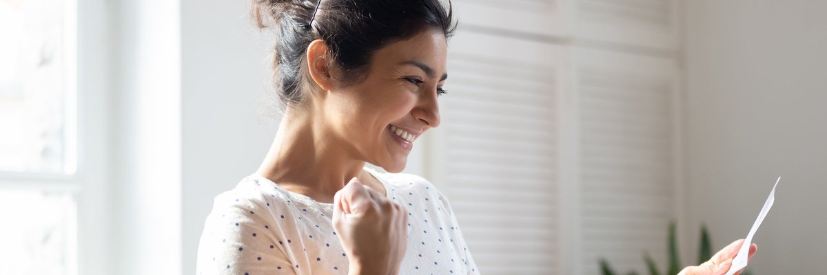 A woman pumps her fist and smiles.