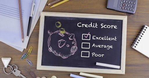 Desk with papers and pencils and a chalk board that says credit score excellent