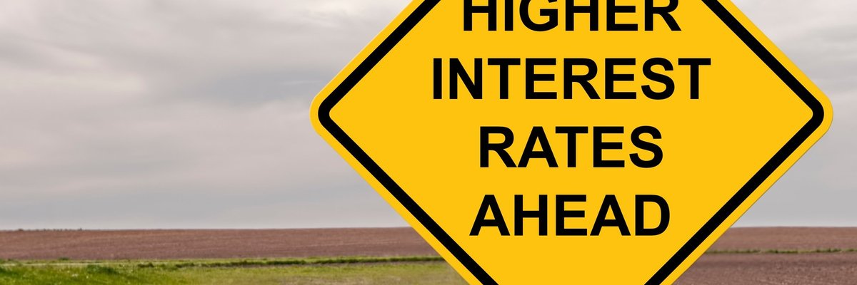 A yellow road sign reading Higher Interest Rates Ahead.