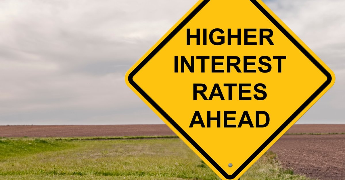 A yellow road sign reading Higher Interest Rates Ahead.