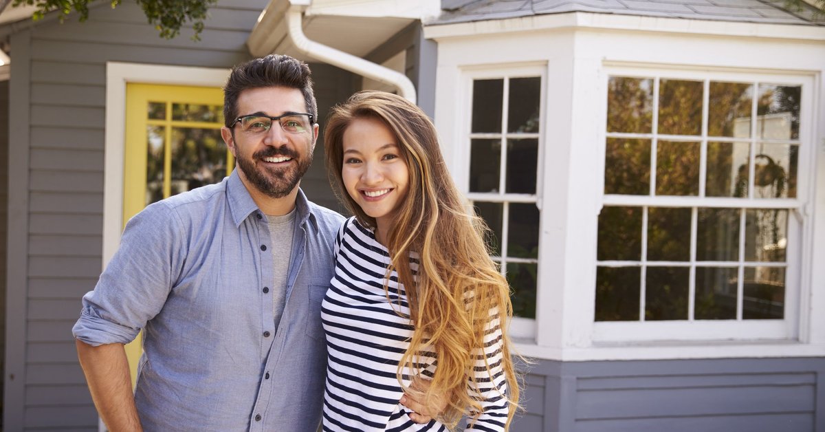 Home with a couple standing in front of it