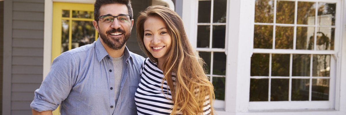 Home with a couple standing in front of it