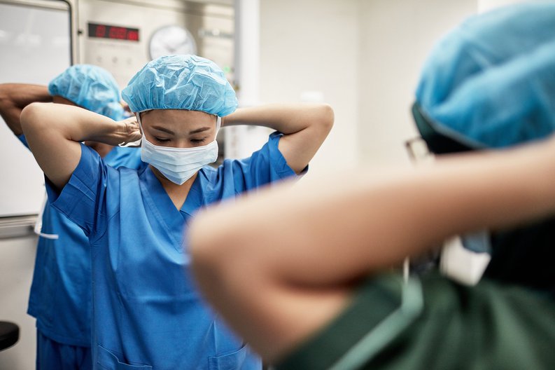Hospital workers putting on masks.