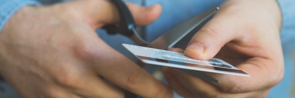 Man cutting up a credit card with scissors