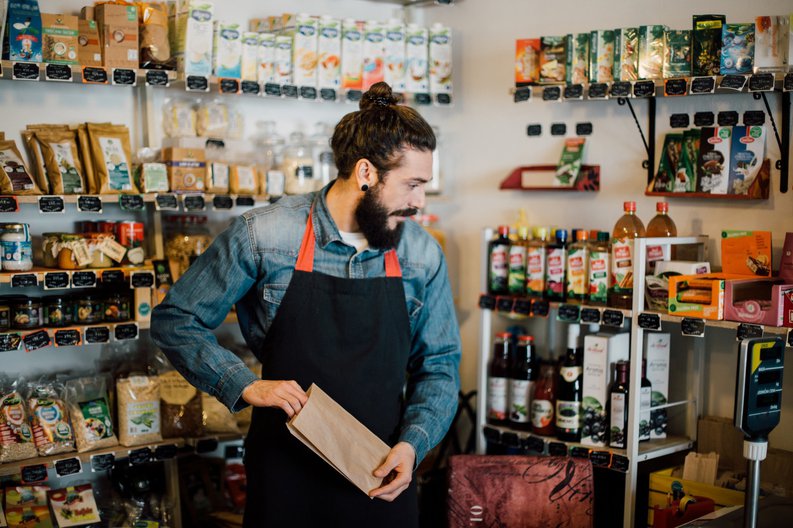 A male employee bagging items in a health food store.