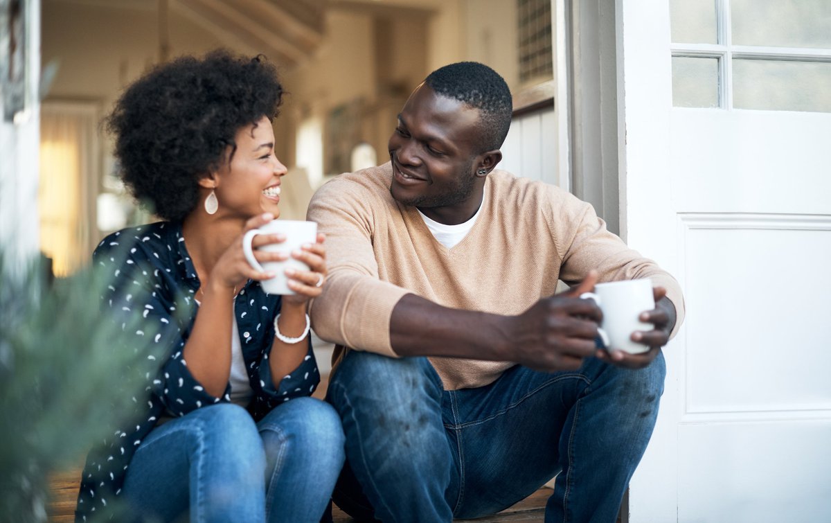 husband and wife sitting on porch drinking coffee