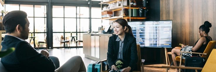 A man and woman sitting in a luxury airport lounge.