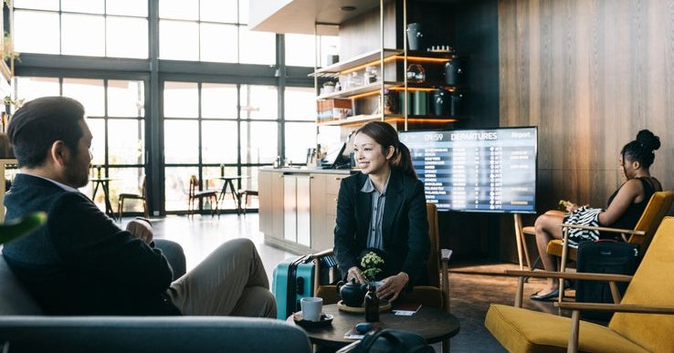 A man and woman sitting in a luxury airport lounge.